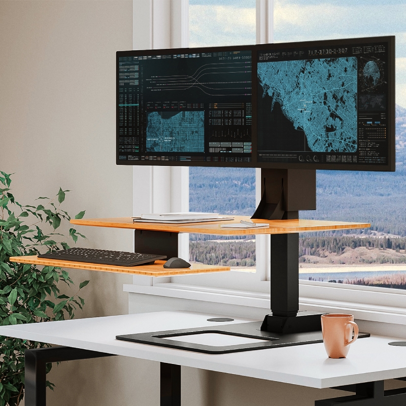 UPLIFT E7 Electric Standing Desk Converter on a fixed height desk to add ergonomics to the workspace