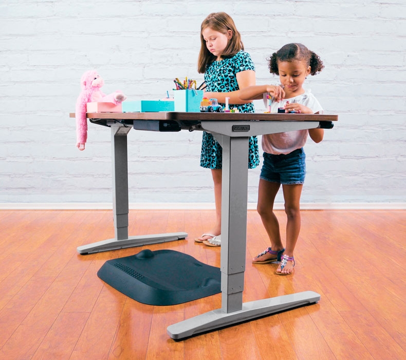 Two girls doing crafts while standing at a Walnut Laminate UPLIFT Desk