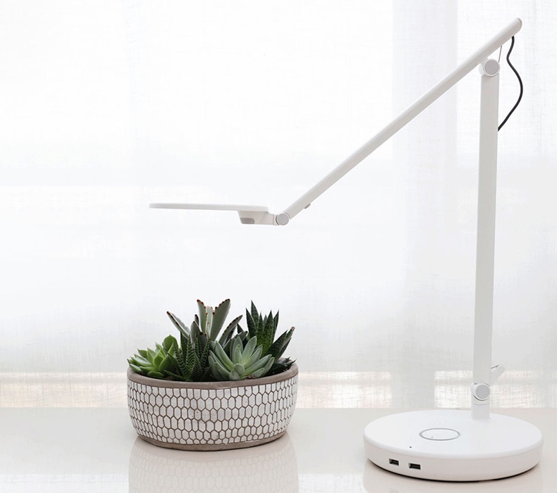 A white Humanscale Nova task light on top of a desk