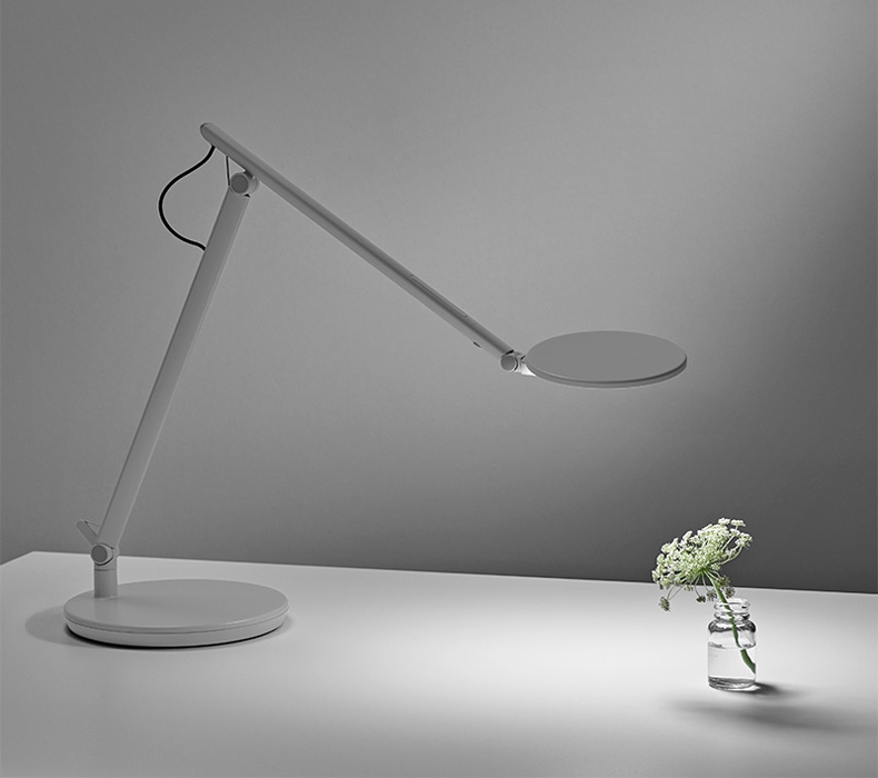 A gray Humanscale Nova task light on top of a desk