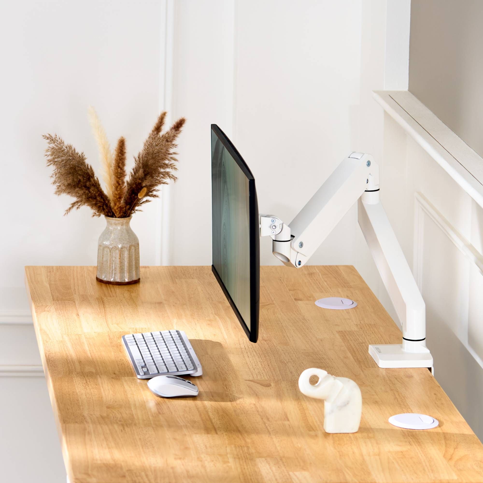 Crestview Monitor Arm by UPLIFT Desk in white on a birch butcher block solid wood desktop