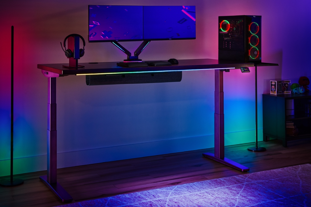 UPLIFT V3 Standing Desk with a gaming setup in a RGB lit room.