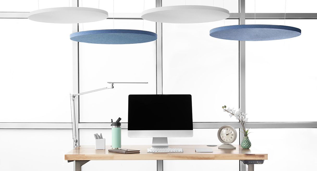 White and blue Circular Acoustic Ceiling Clouds over a standing desk
