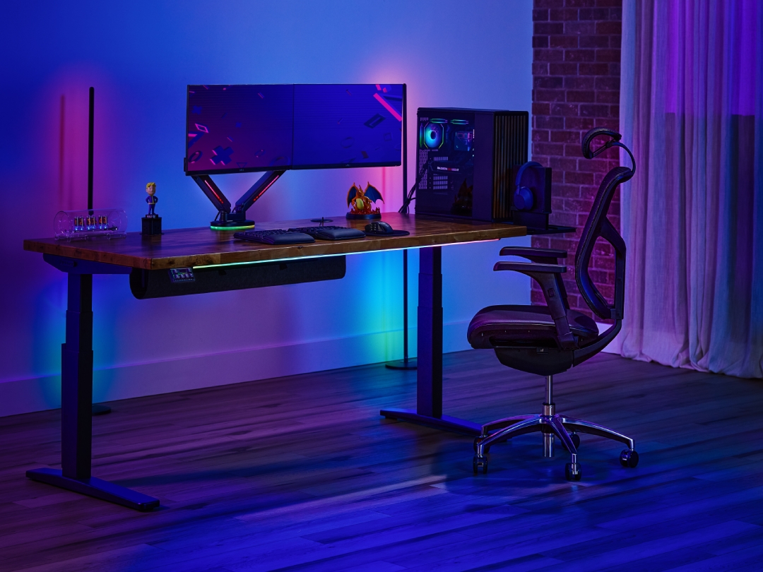 UPLIFT 2-leg Standing Desk with a gaming setup and an UPLIFT J3 Ergonomic Chair.