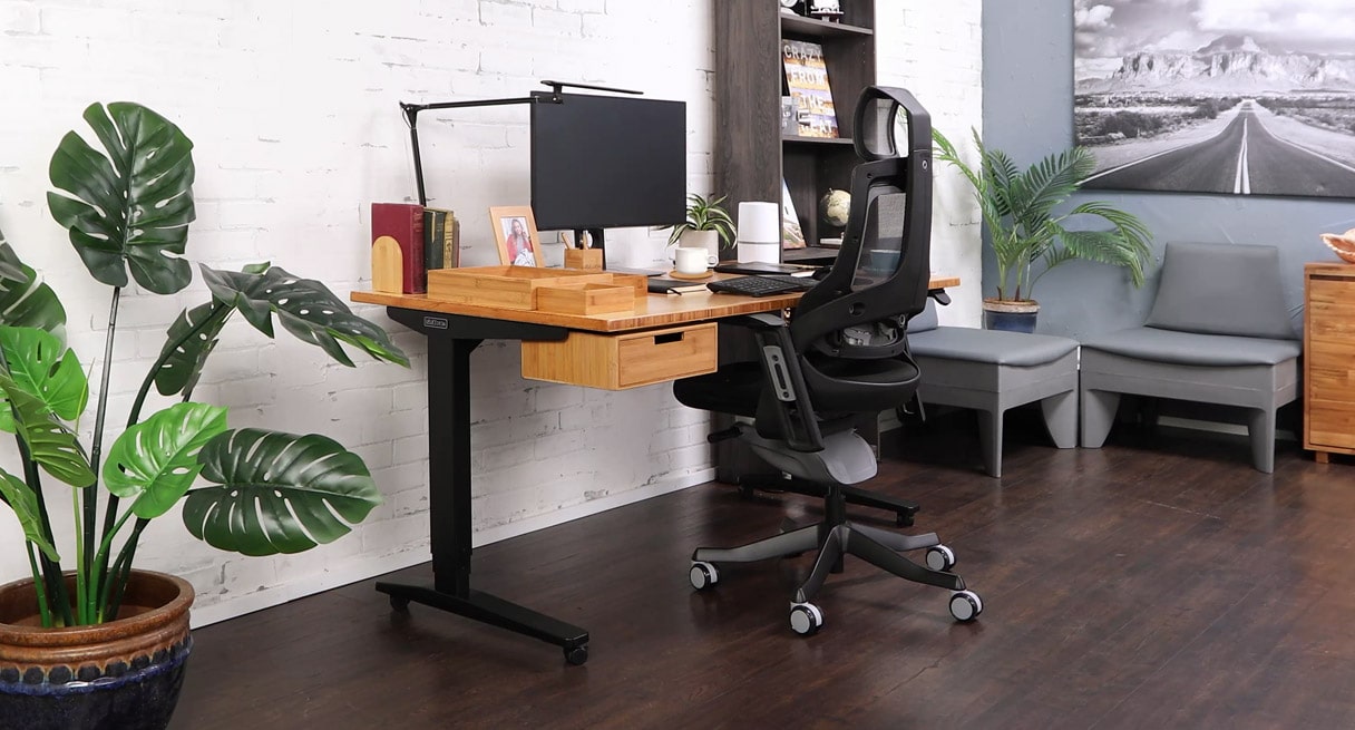 A home office with bamboo standing desk, matching bamboo drawer, and bamboo organizer