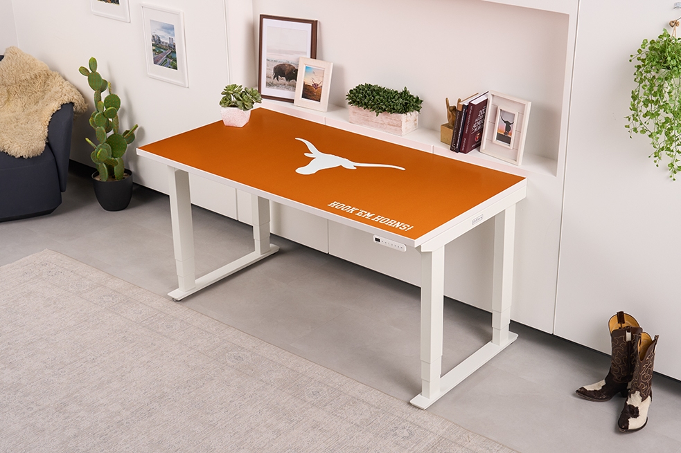 UPLIFT Desk 4-leg standing desk with a Collegiate Collection desktop in a student dorm.