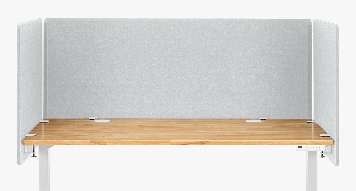 A light gray 3-Sided Tall Acoustic Privacy Screen attached to a standing desk