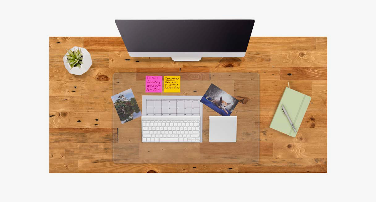 A collage of photos and reminders underneath a Glass Desk Blotter