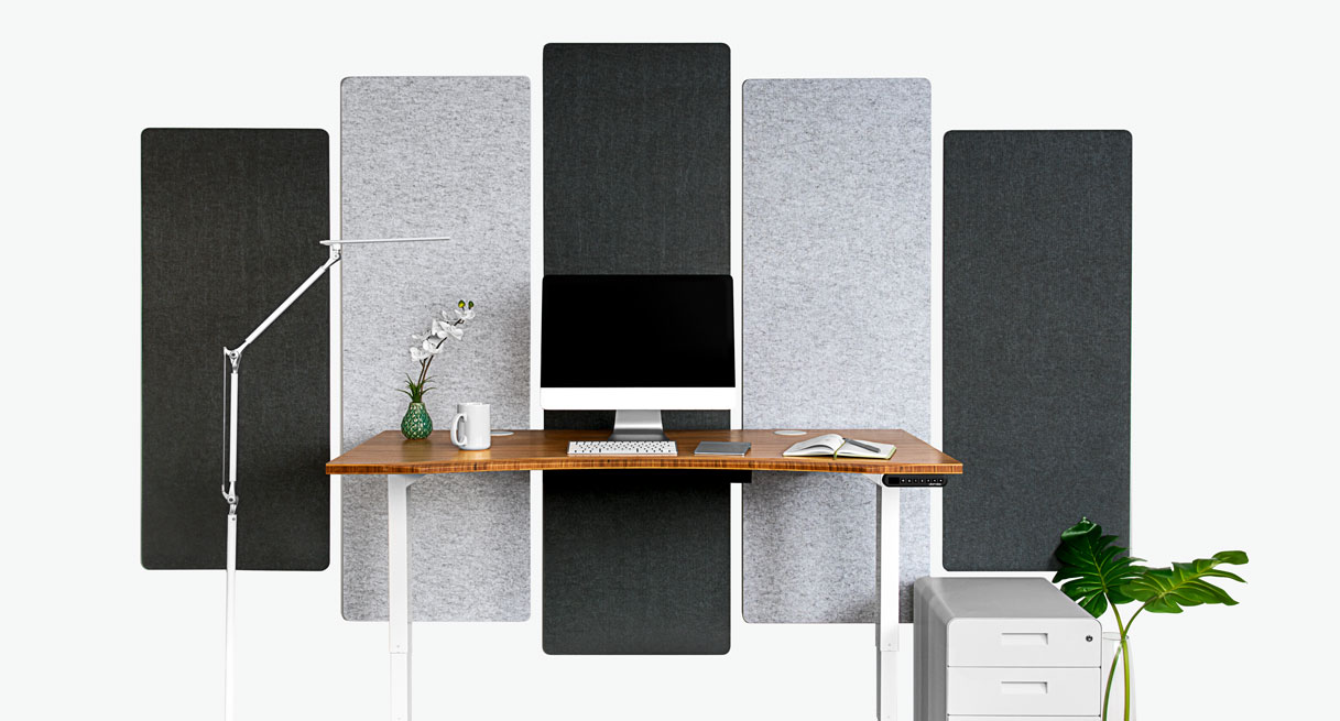 Rectangular Acoustic Wall Panels in light and dark gray behind a sit stand desk