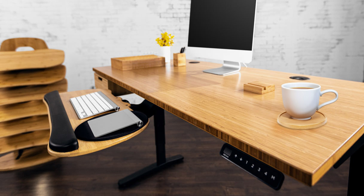 A bamboo standing desk with the natural bamboo color desk organizer and matching keyboard tray and bamboo drawer