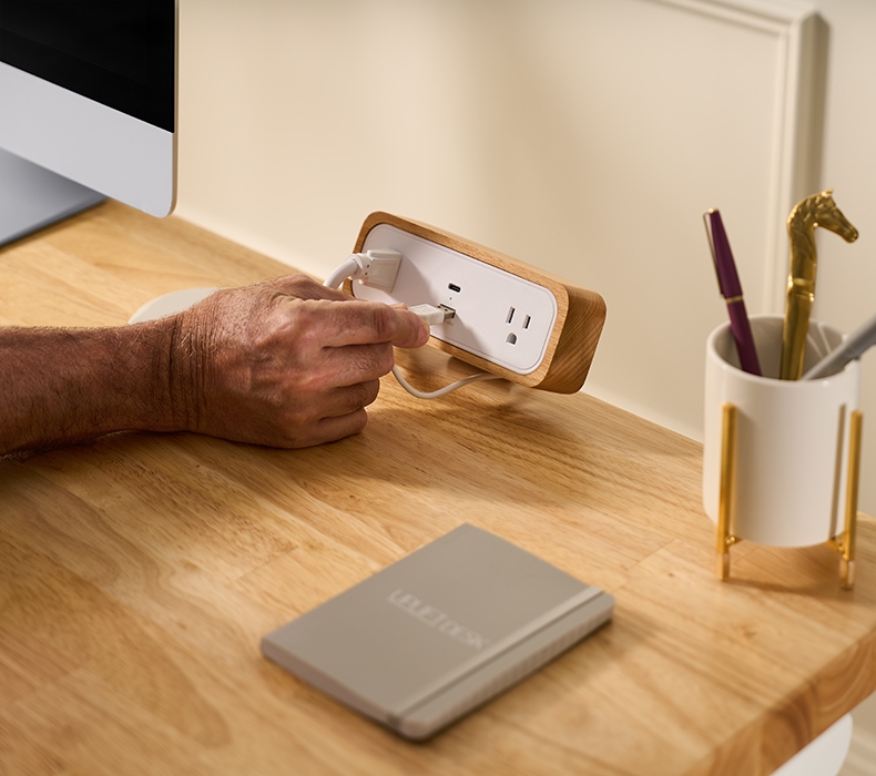 Hand inserting a charging cable into a DuoMount Power Strip