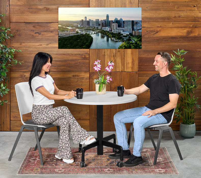 Two people having coffee while seated in Flex Chairs at an UPLIFT Height Adjustable Bistro Table