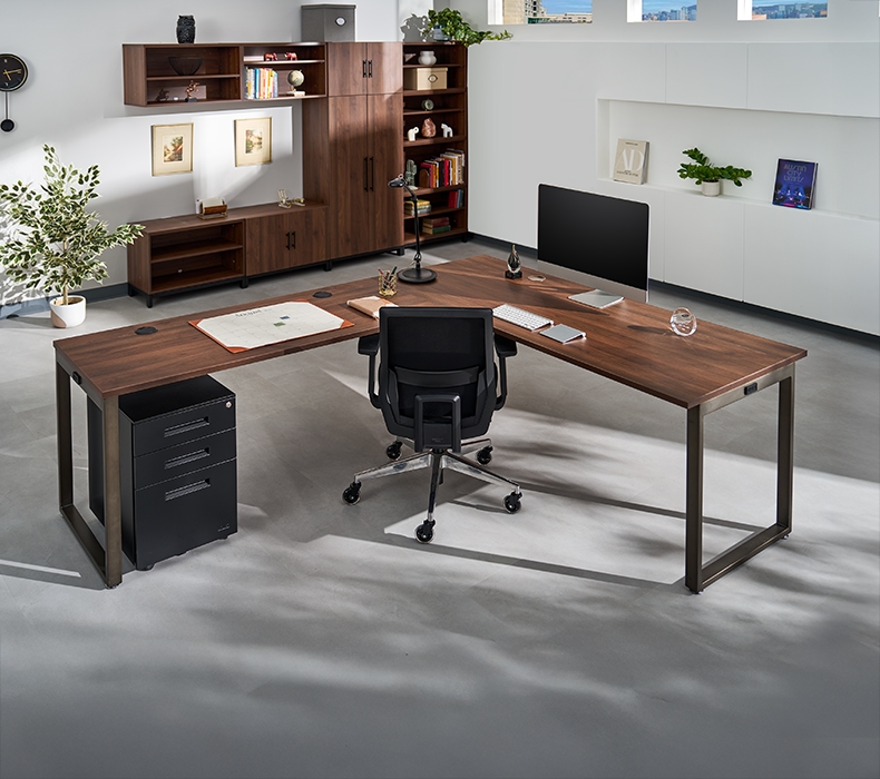 UPLIFT O-Leg L-Shaped Desk in walnut laminate with black frame featuring an UPLIFT Desk 3-drawer square file cabinet. Mopac cabinets in Walnut laminate line the wall in the background.