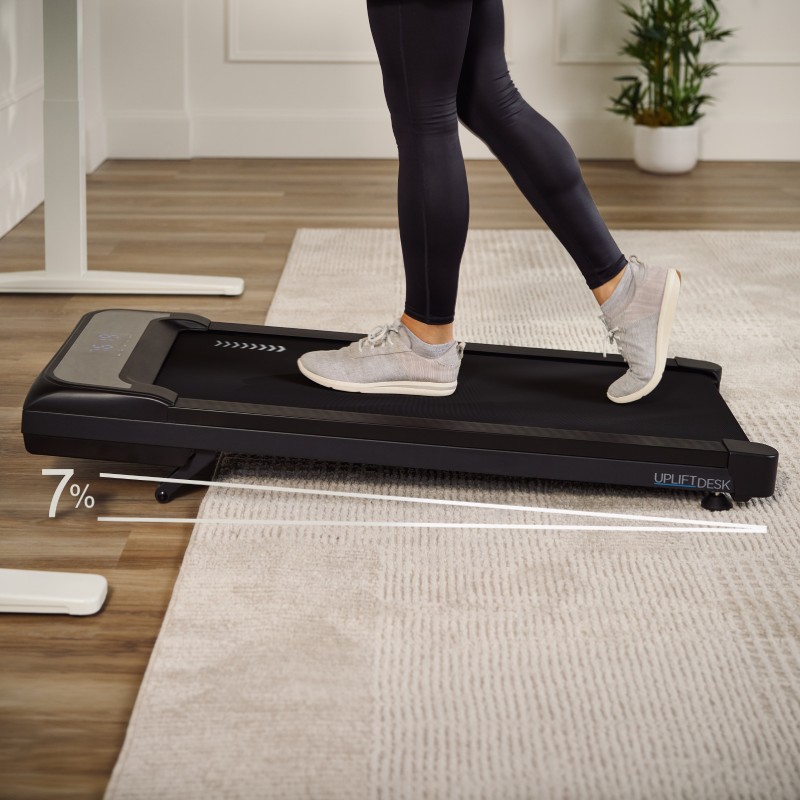 Inclining portable walking pad in use, showing only the lower body