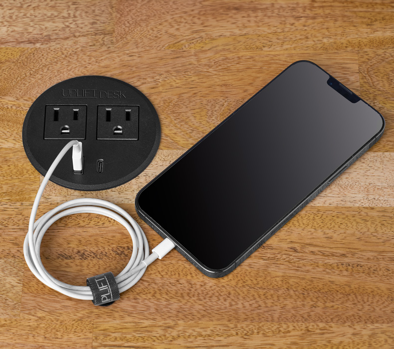 A Power Grommet with USB charging a smartphone