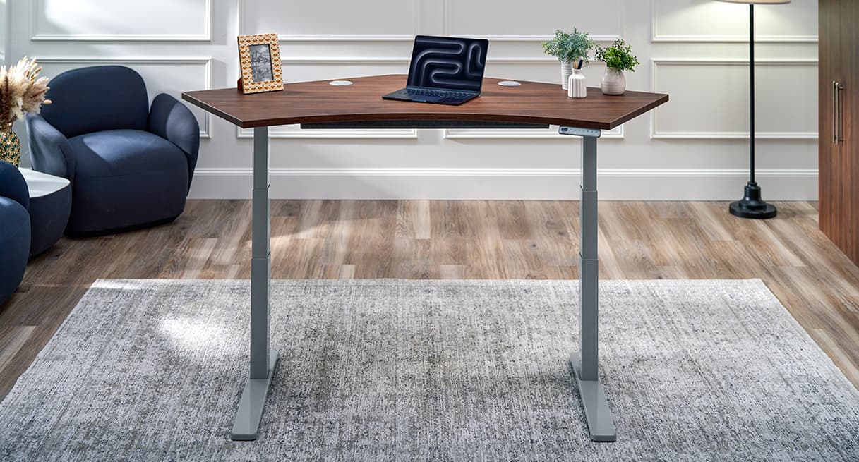 UPLIFT 120-Degree Standing Desk with a Walnut Laminate top and gray frame in a home office setup.