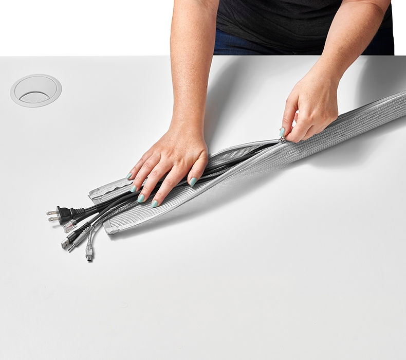 Easy to manage 30-inch Gray Zipped Cable Sleeve by UPLIFT Desk on top of a White Laminate Desktop