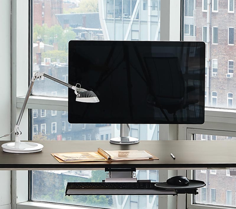 A Humanscale Element Vision LED Light sitting on a desk