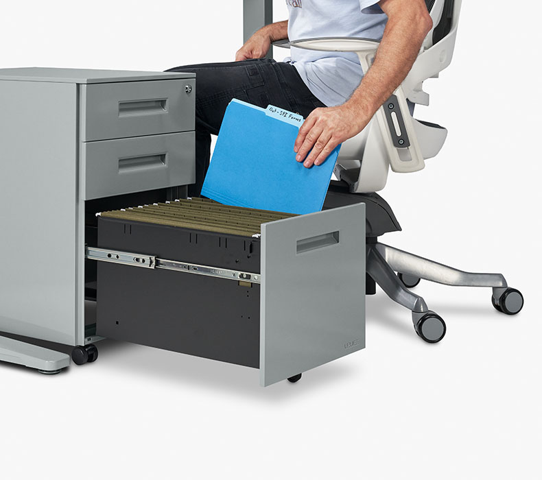 A person places a file in the bottom drawer of a 3-Drawer Square File Cabinet