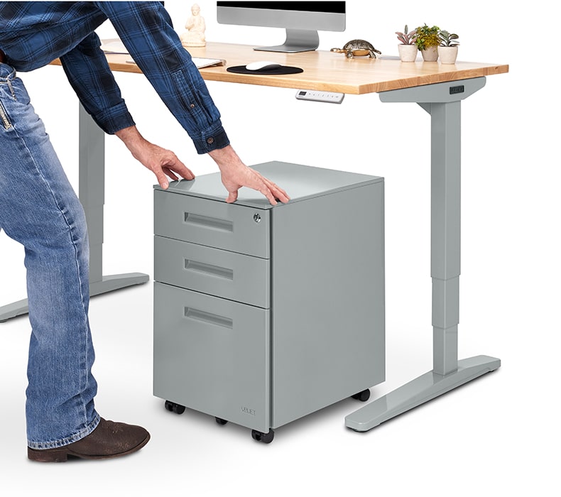 3-Drawer Square File Cabinet being rolled under an UPLIFT ergonomic desk