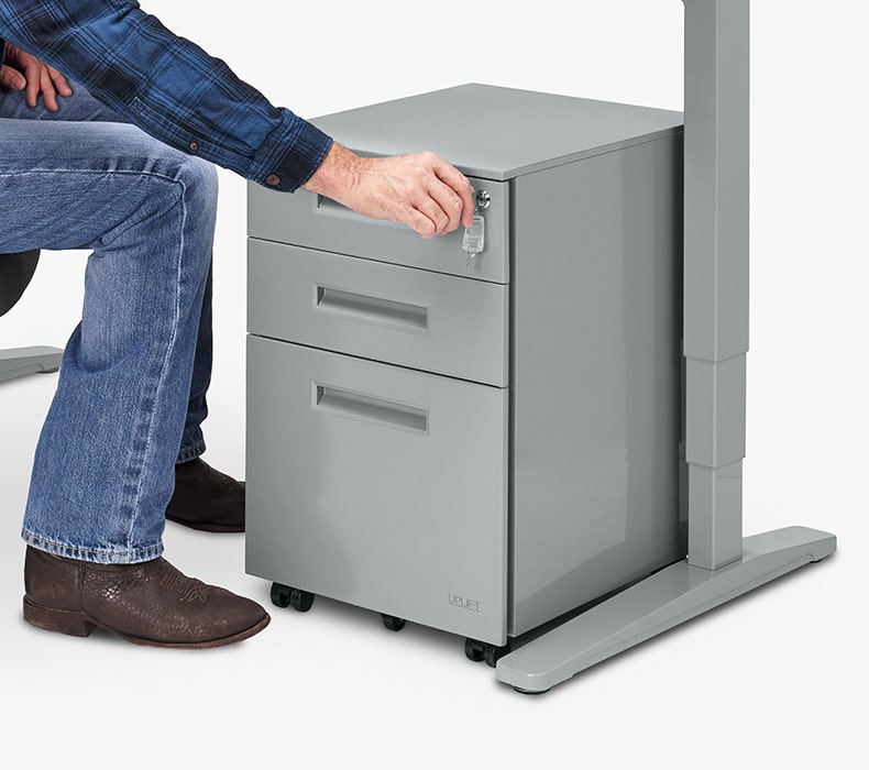 A man locking the drawers of an UPLIFT 3-Drawer Square File Cabinet