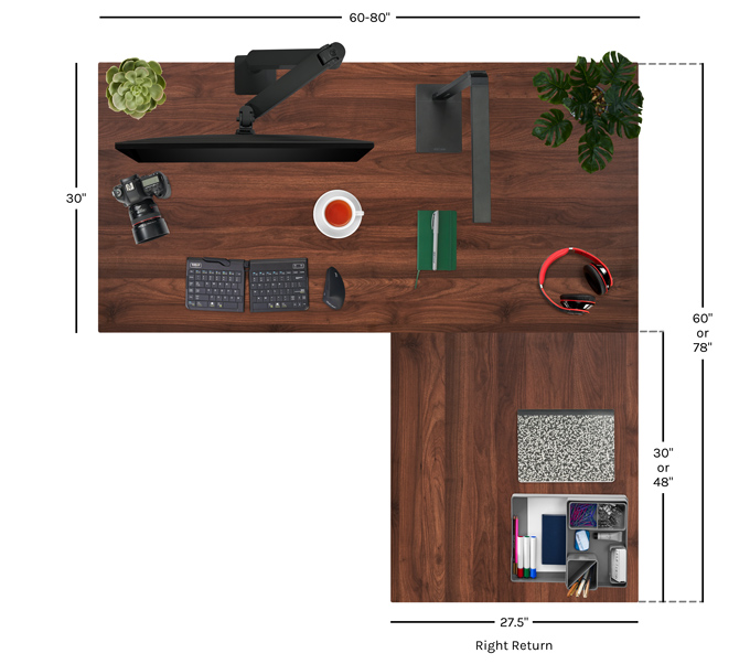 Overhead view of L-shaped walnut desktop showing dimensions and workspace layout. Keyboard, monitor, and accessories arranged on the surface.